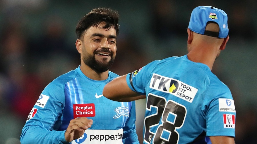 ADELAIDE, AUSTRALIA - DECEMBER 14:  Rashid Khan of the Strikers with  Jake Weatherald of the Strikers after he bowled the ball to dismiss  Moises Henriques of the Sixers for 24 runs. Caught  Matt Short of the Strikers  during the Men's Big Bash League match between the Adelaide Strikers and the Sydney Sixers at Adelaide Oval, on December 14, 2022, in Adelaide, Australia. (Photo by Sarah Reed - CA/Cricket Australia via Getty Images)